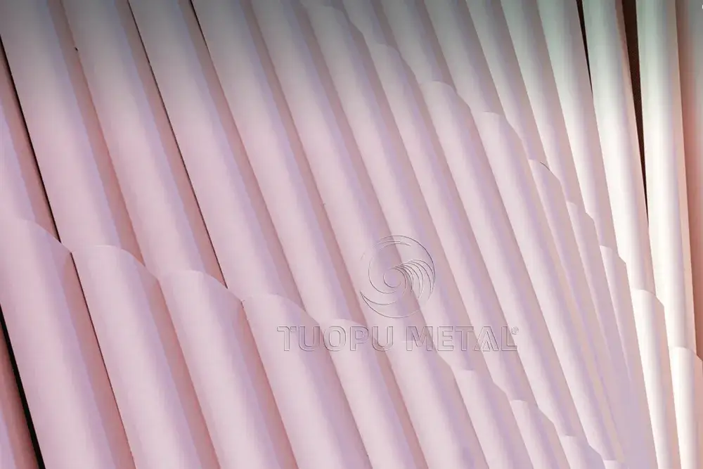 A close-up of the pink aluminum honeycomb panel façade demonstrates the fusion of innovative building materials, energy-efficient design and architectural aesthetics.