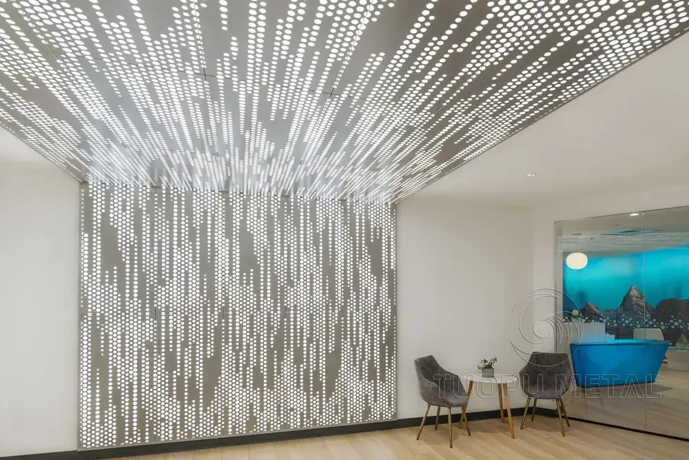 The ceiling and walls in the office corridor are seamlessly connected with perforated aluminum panels with lights.