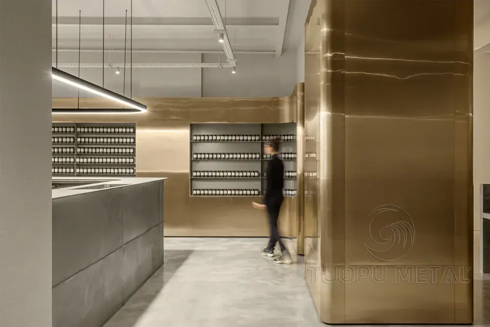 Inside a hair salon, the walls are made of golden aluminum panels.