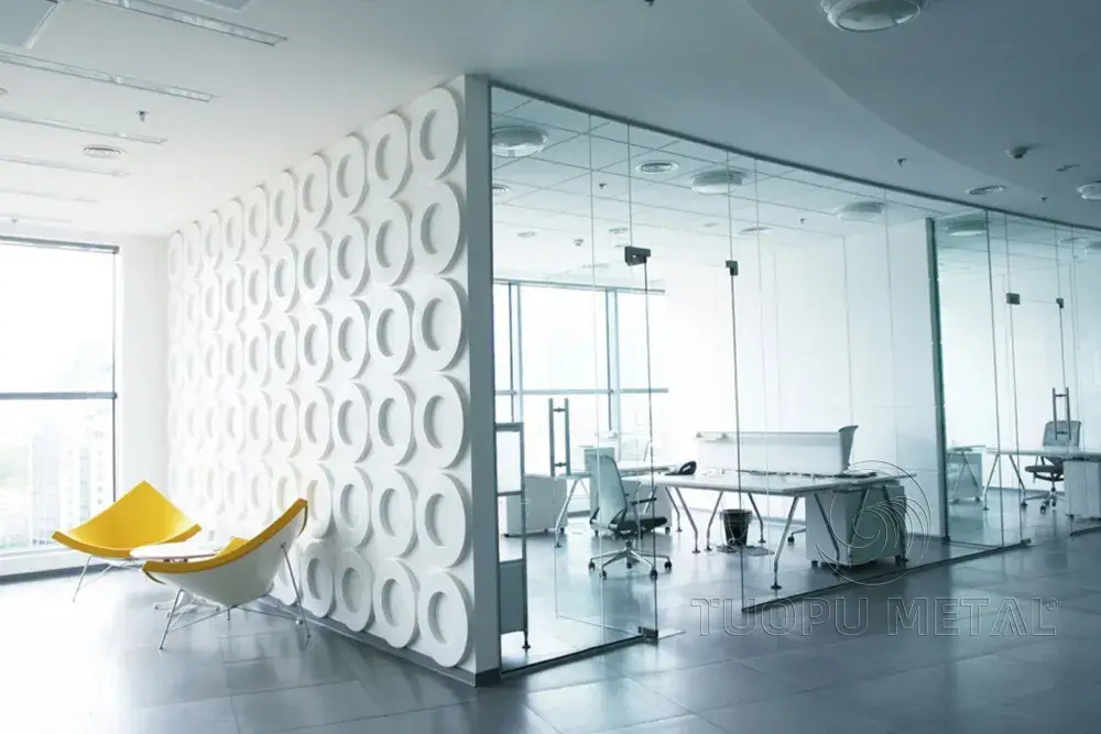 Inside a brightly lit office, the walls are made of circular aluminum panels.