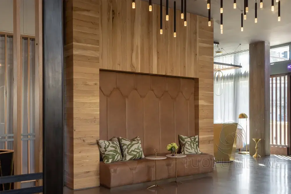 In a hotel lobby, the walls are made of wood-grain aluminum panels.