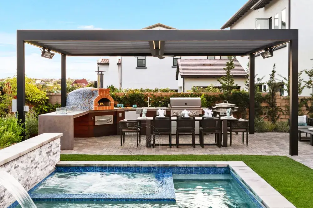 Showing a home's outdoor louvered pavilion that doubles as an outdoor kitchen, complete with a dining table and barbecue grill, next to a swimming pool.
